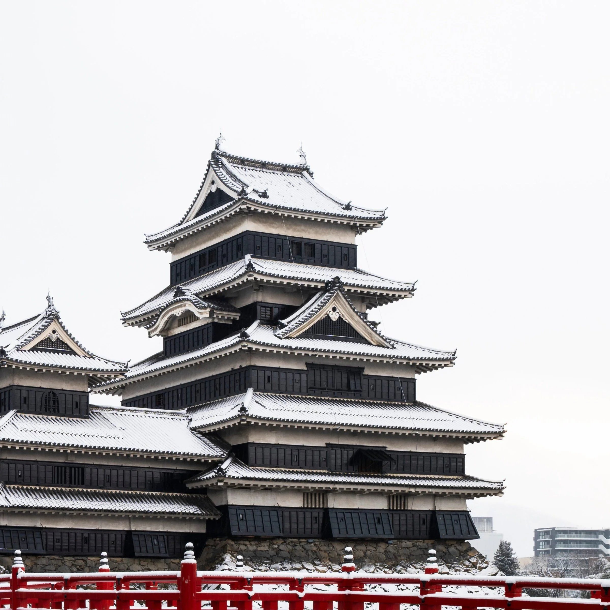 Close-up of Matsumoto Castle's black and white tiered keep above the red bridge, Nagano Prefecture, Japan
