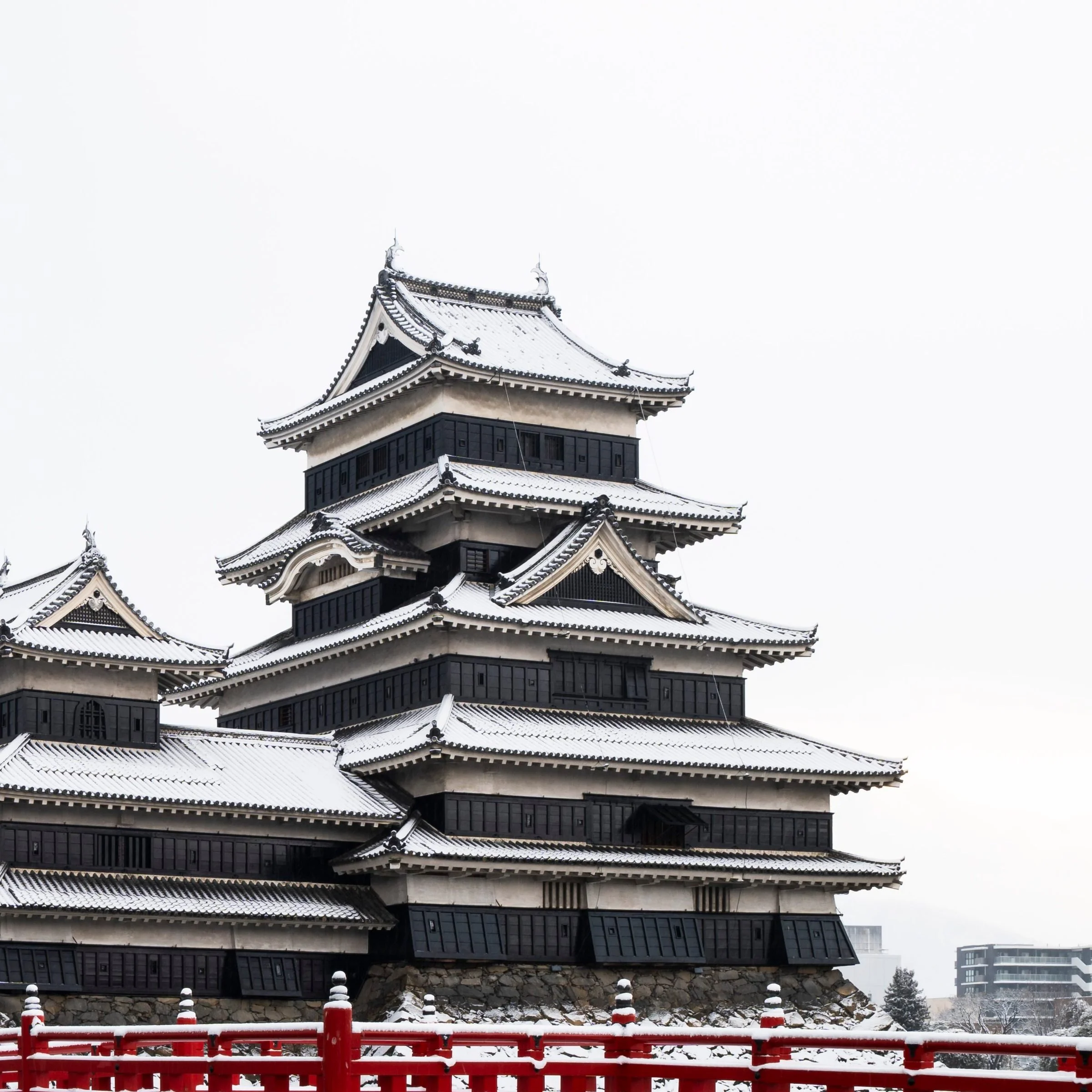 Close-up of Matsumoto Castle's black and white tiered keep above the red bridge, Nagano Prefecture, Japan