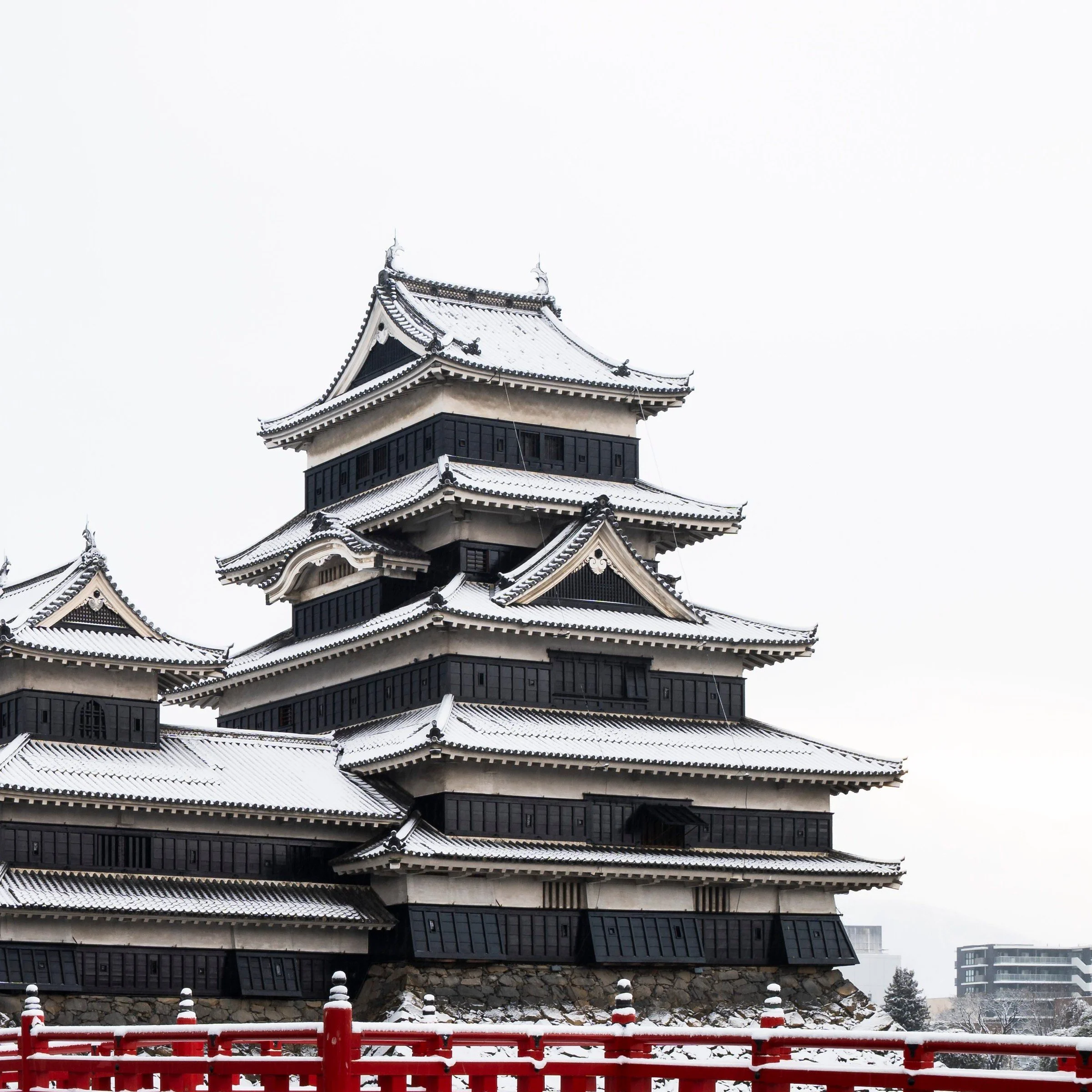 Close-up of Matsumoto Castle's black and white tiered keep above the red bridge, Nagano Prefecture, Japan