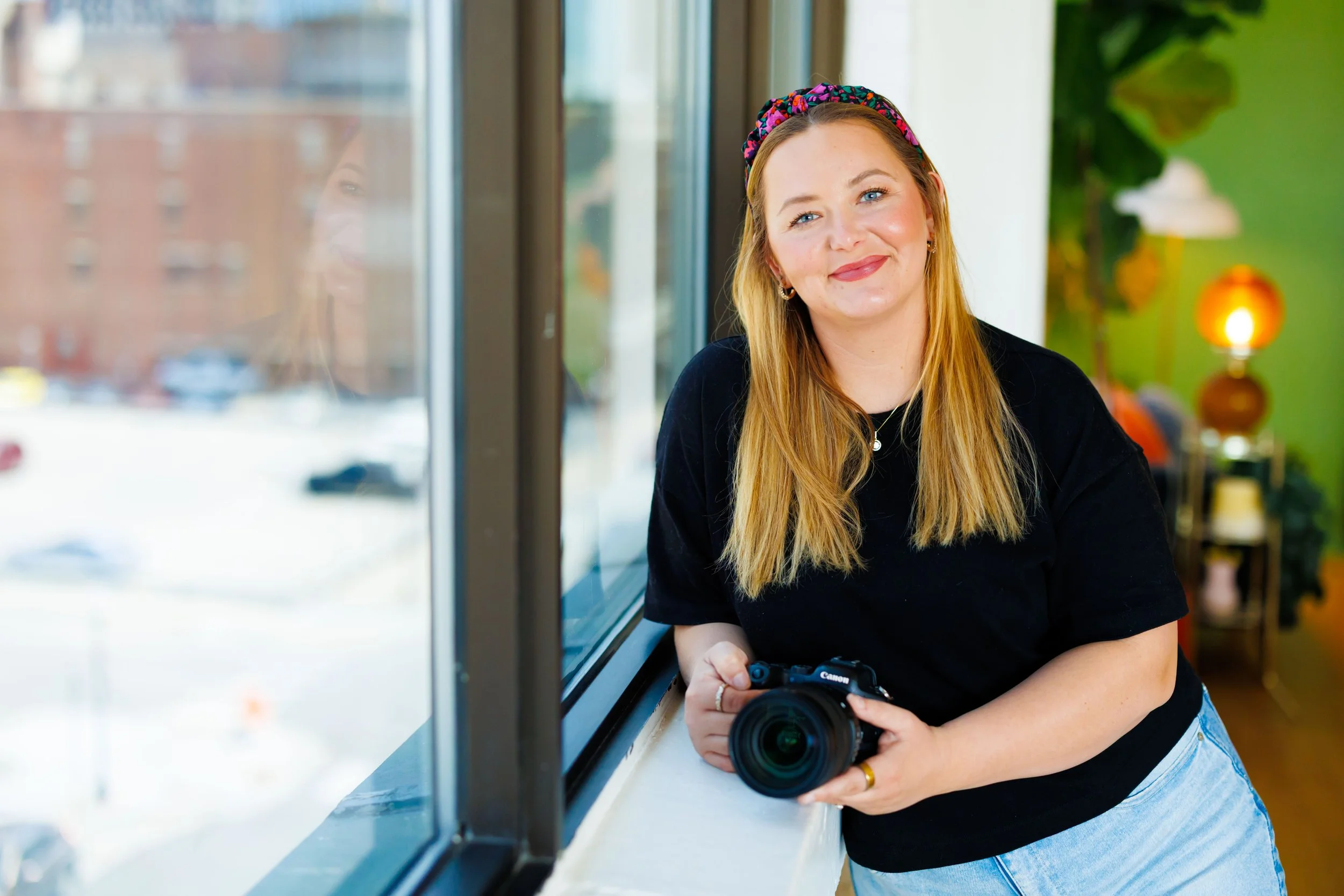 branding photo of woman with a camera wearing a black shirt