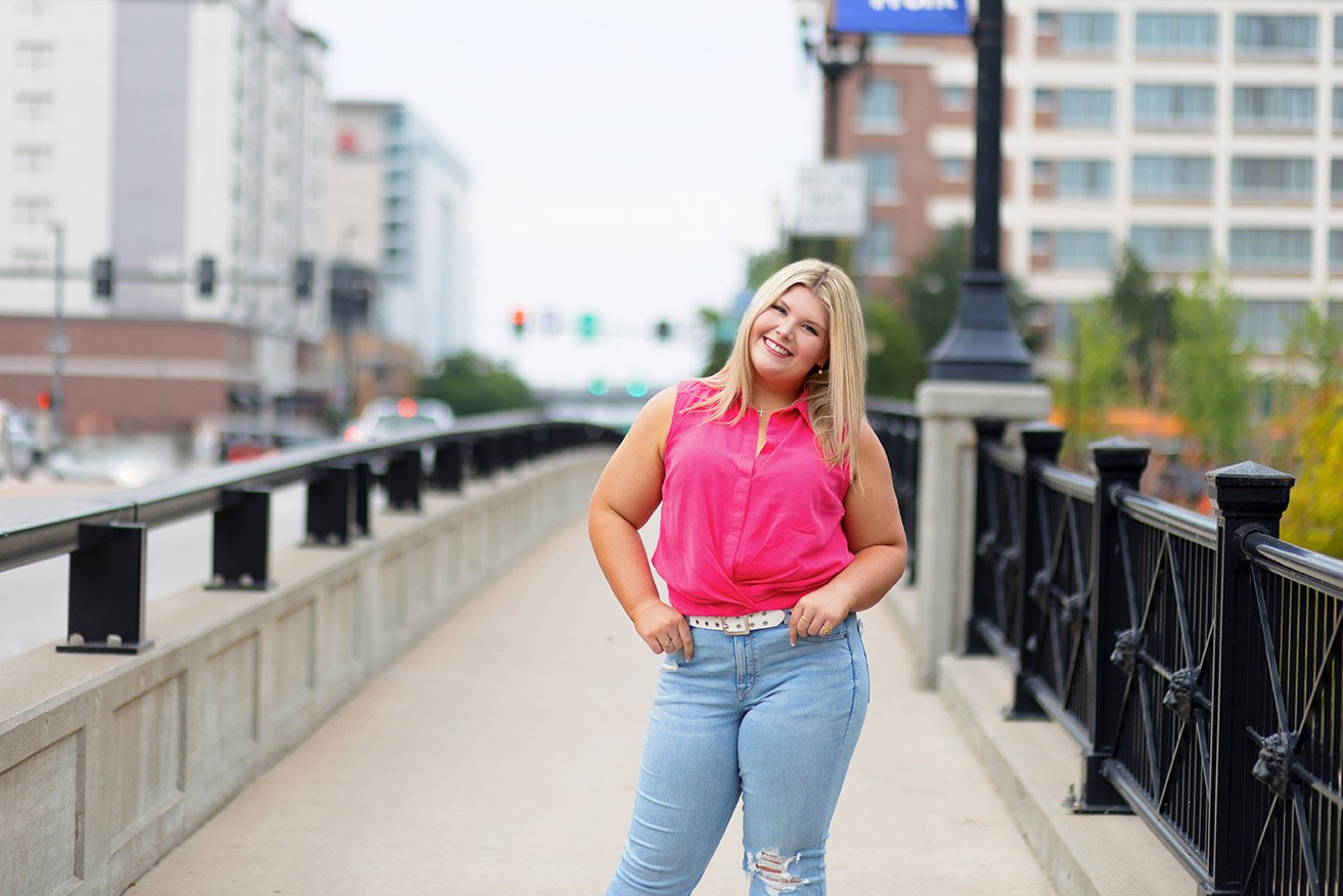 senior photo of a girl in a pink shirt in the Old Market, Omaha, NE