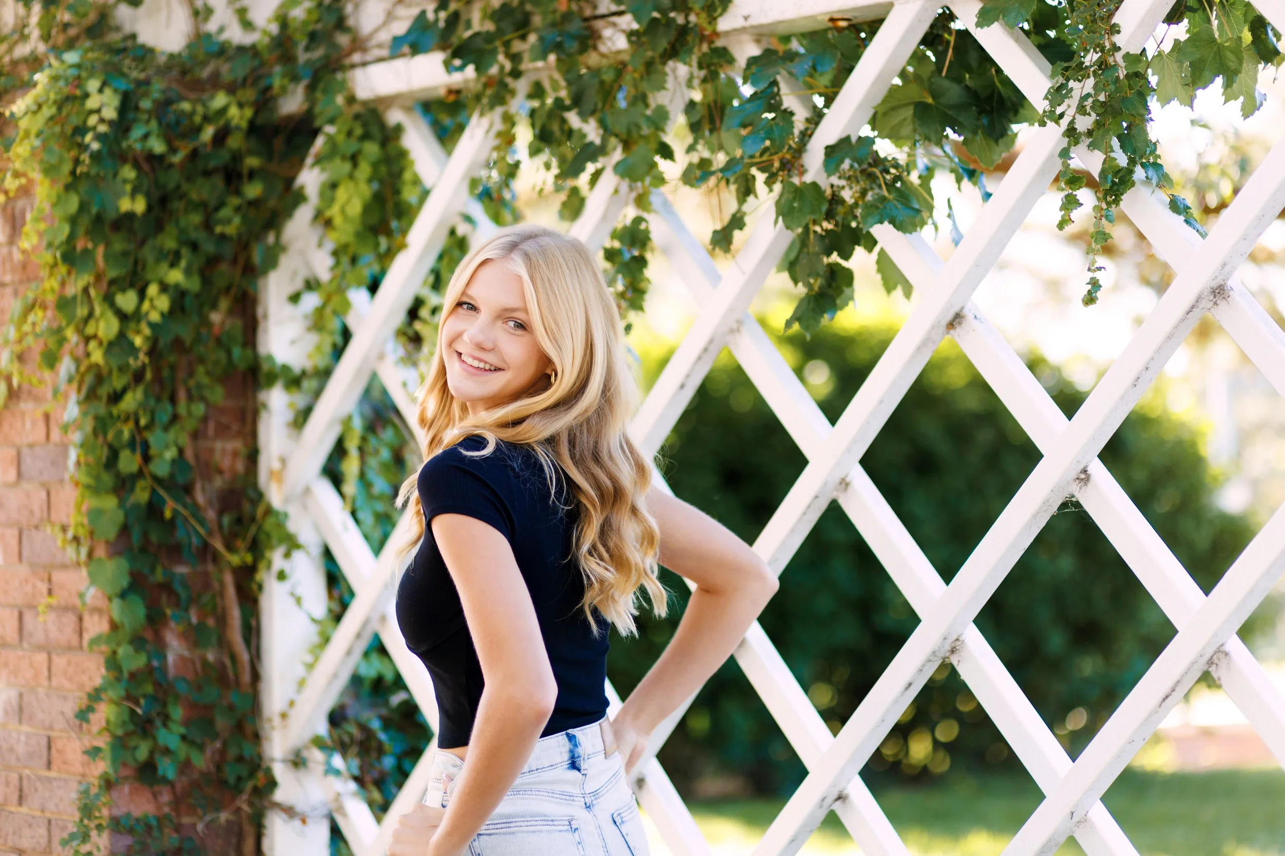 senior photographer image of a girl in front of greenery in Omaha, NE