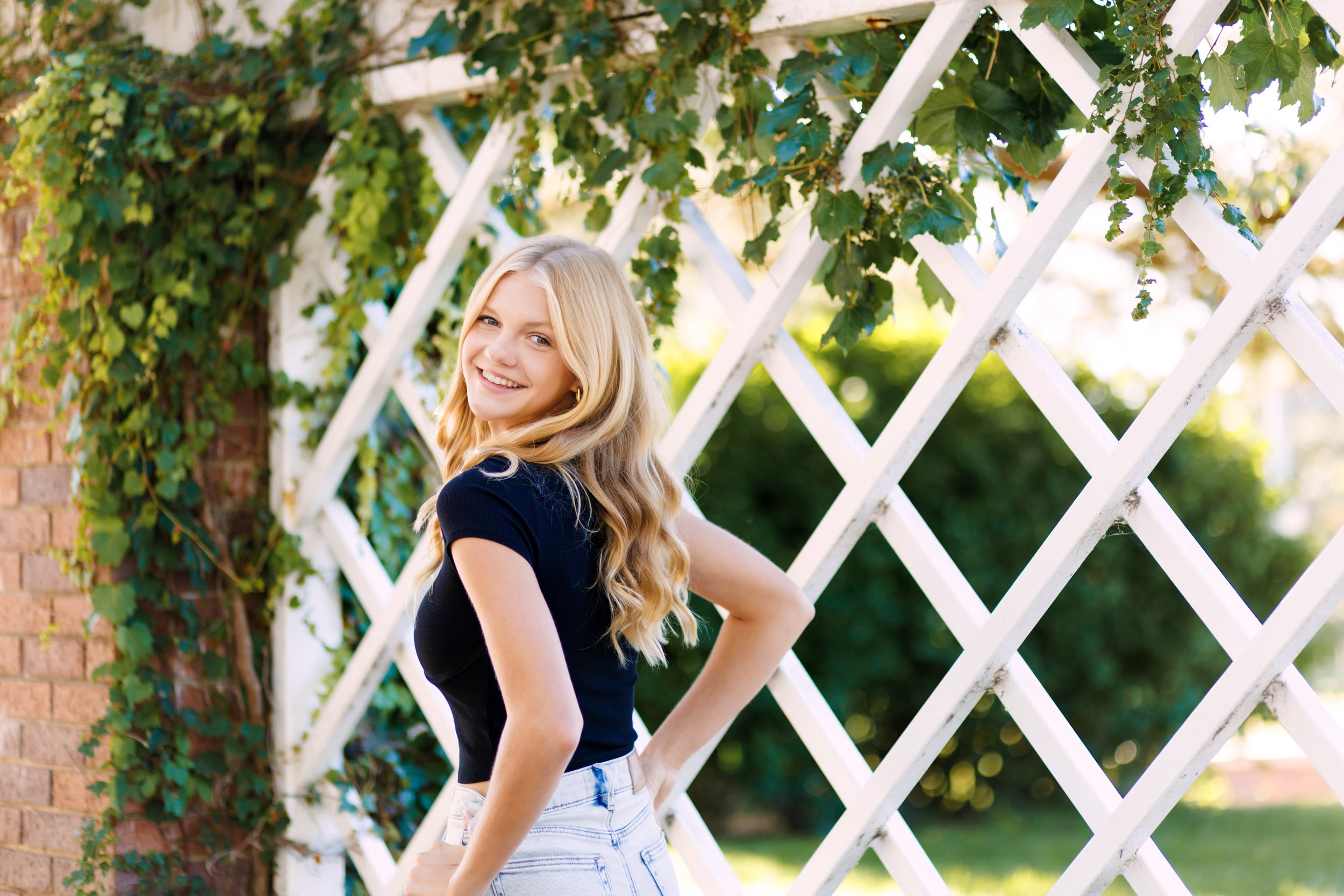 senior photographer image of a girl in front of greenery in Omaha, NE