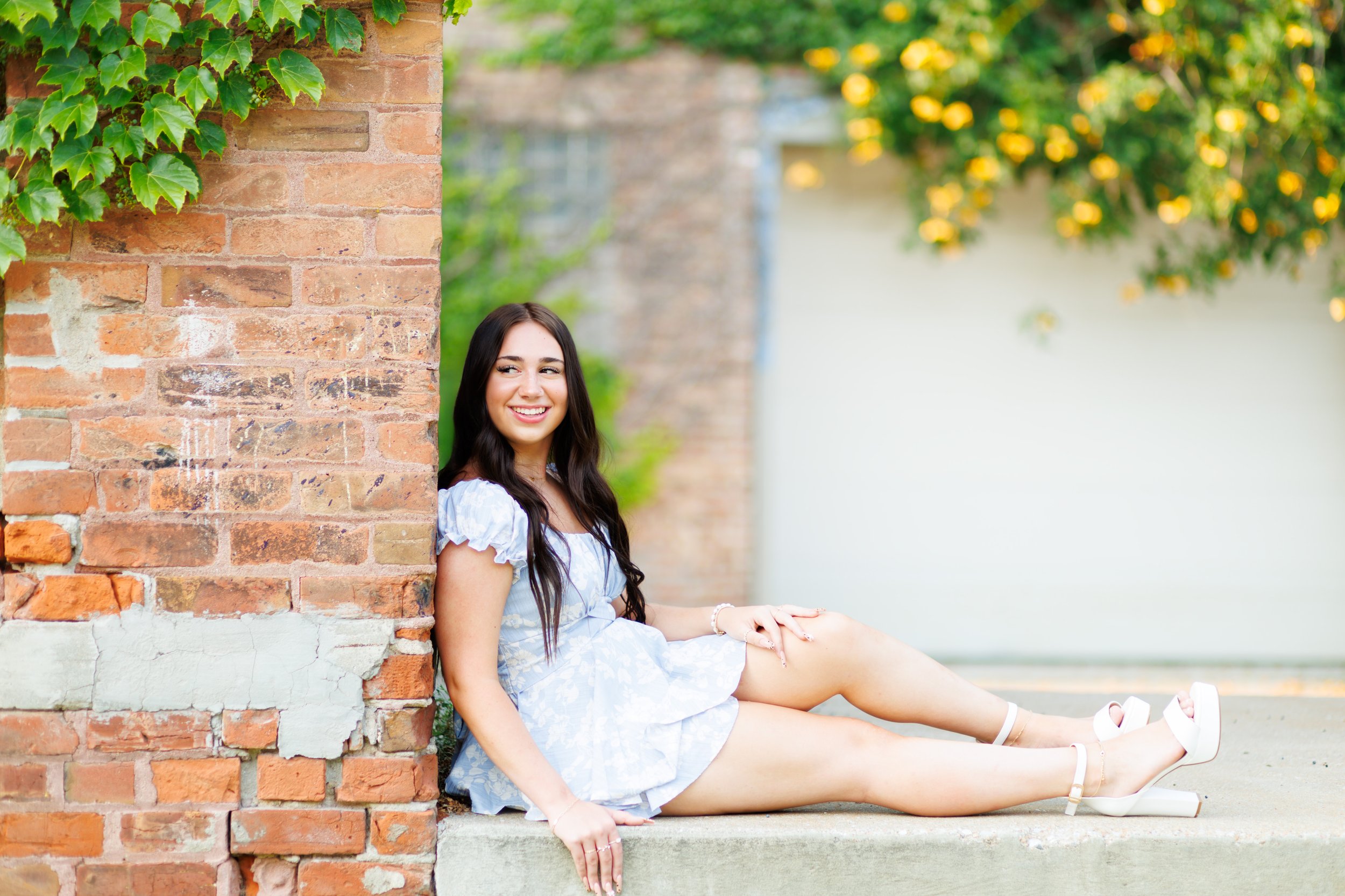 senior photo of a girl by a brick wall in Omaha, NE