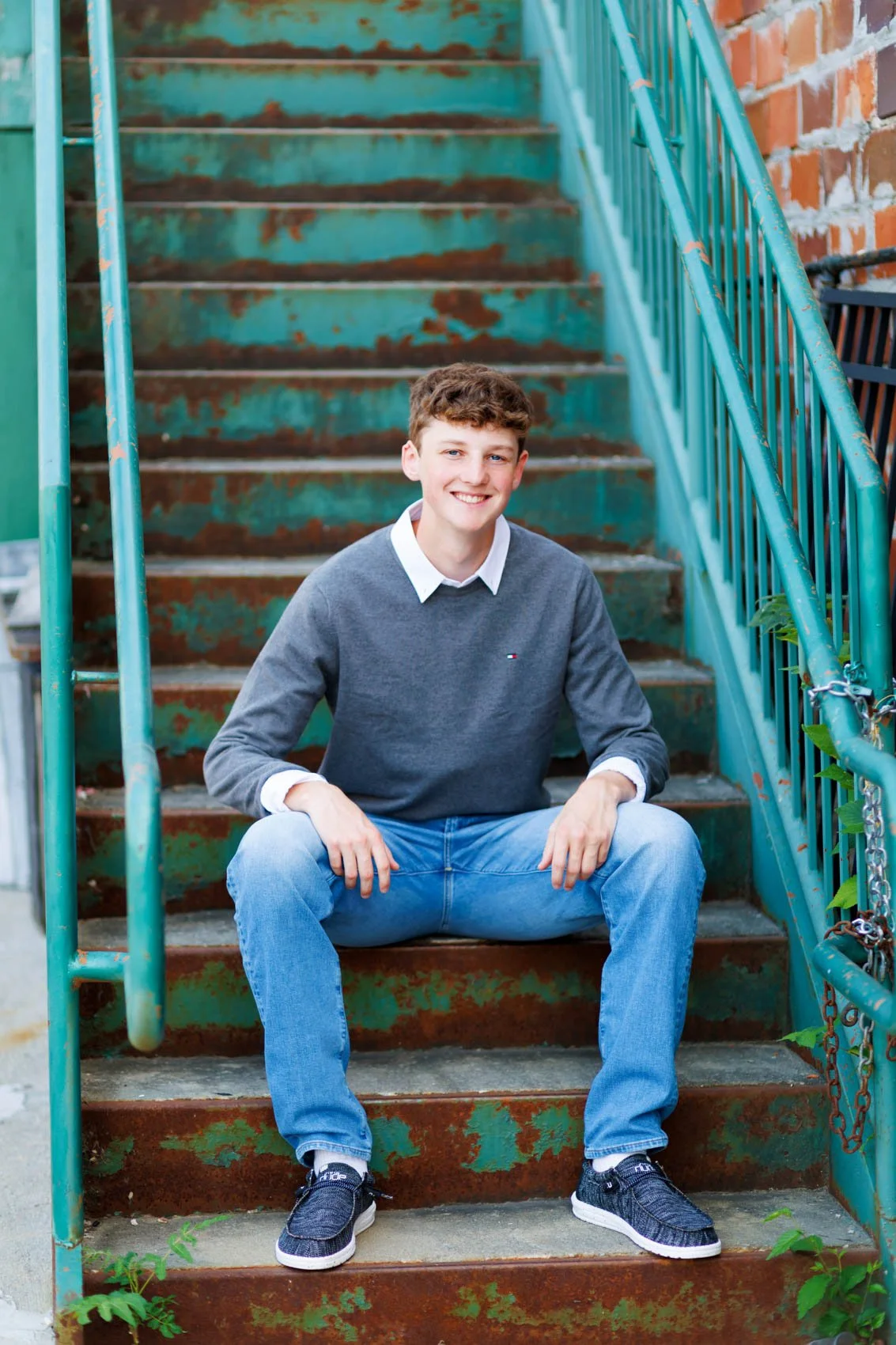Senior photo of a boy on rusted stairs in Council Bluffs, IA