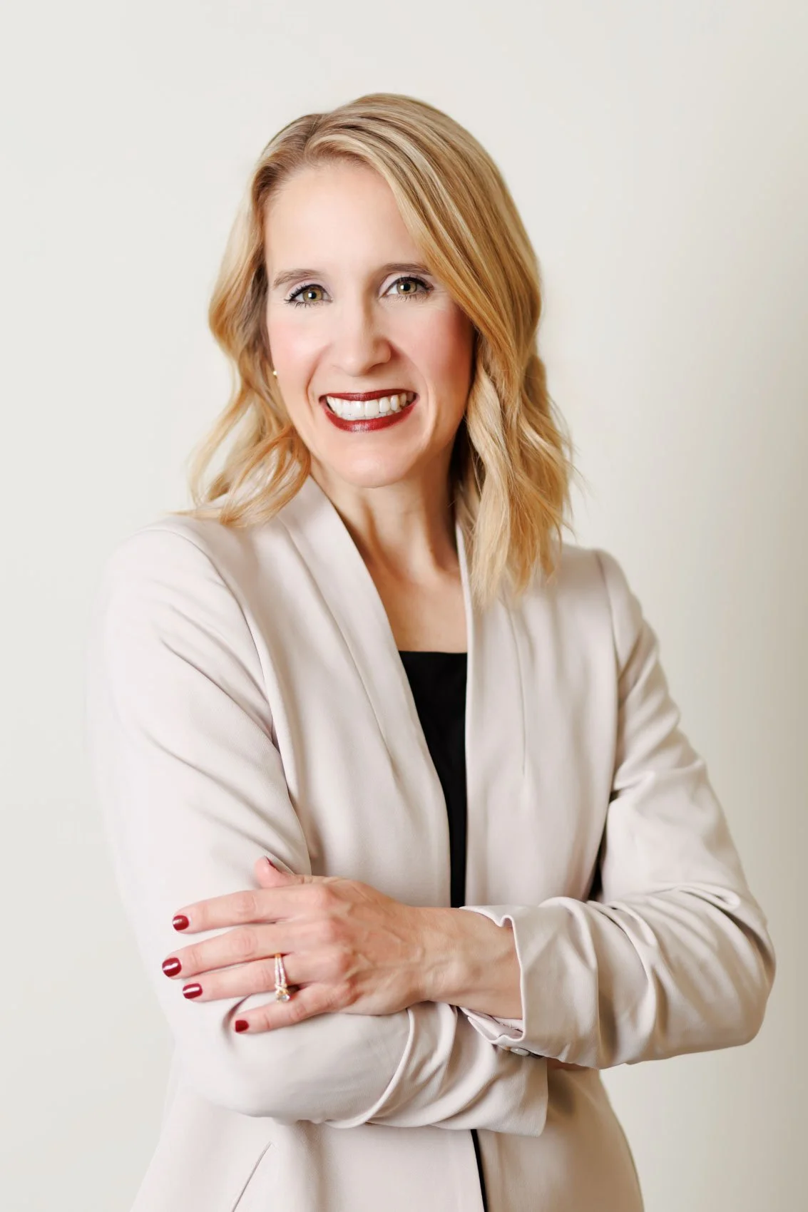 professional headshot of a woman in an ivory blazer, in Omaha, NE