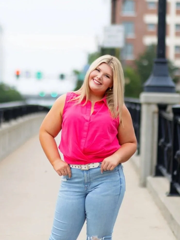 senior photo of a girl in a pink top in downtown Omaha, NE