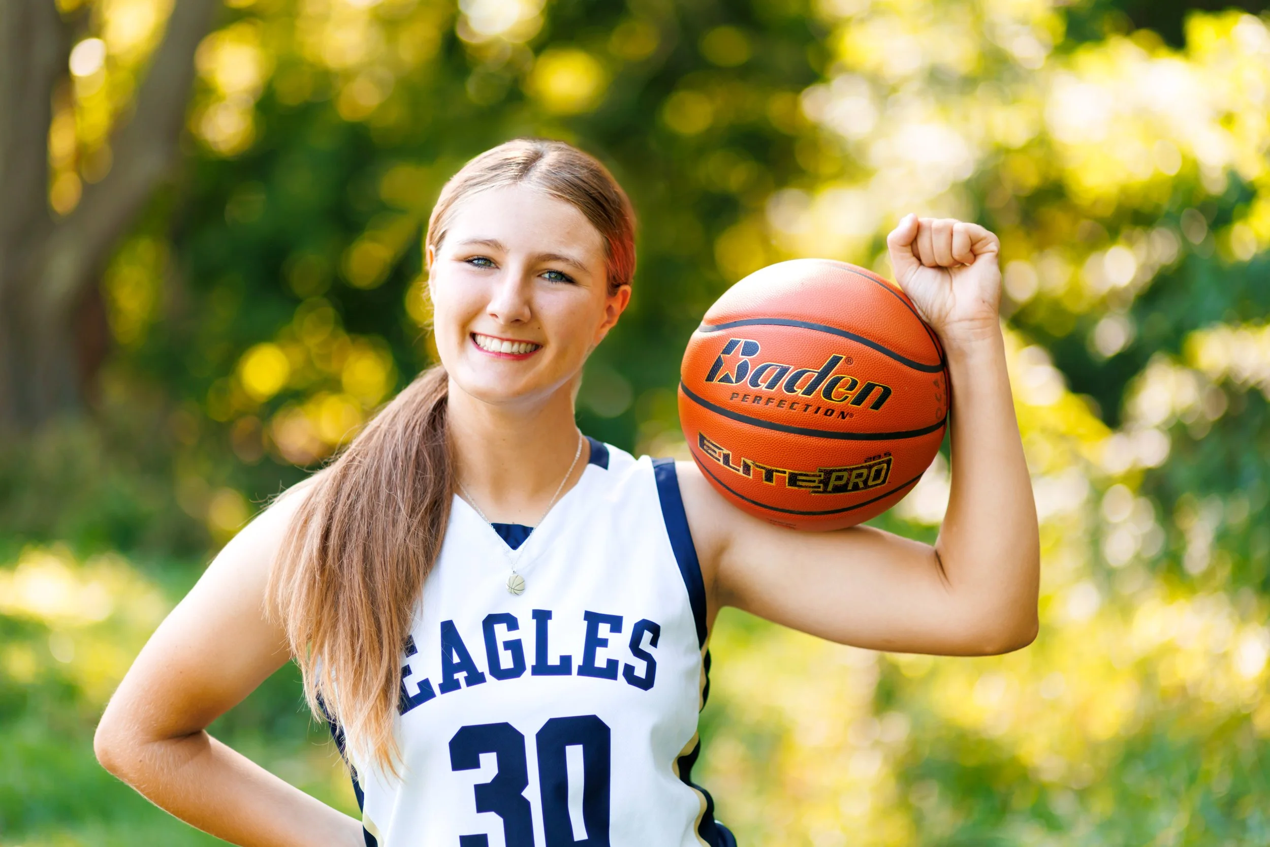 photo of senior girl with basketball in her jersey