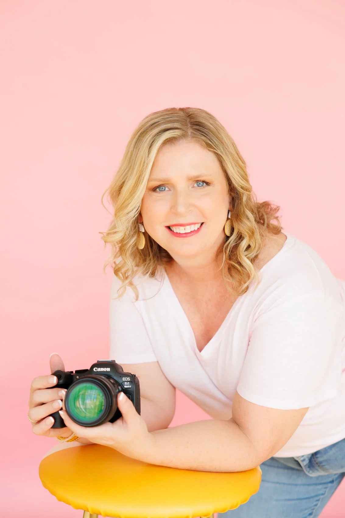 Headshot of Carrie Newell with camera, Photographer