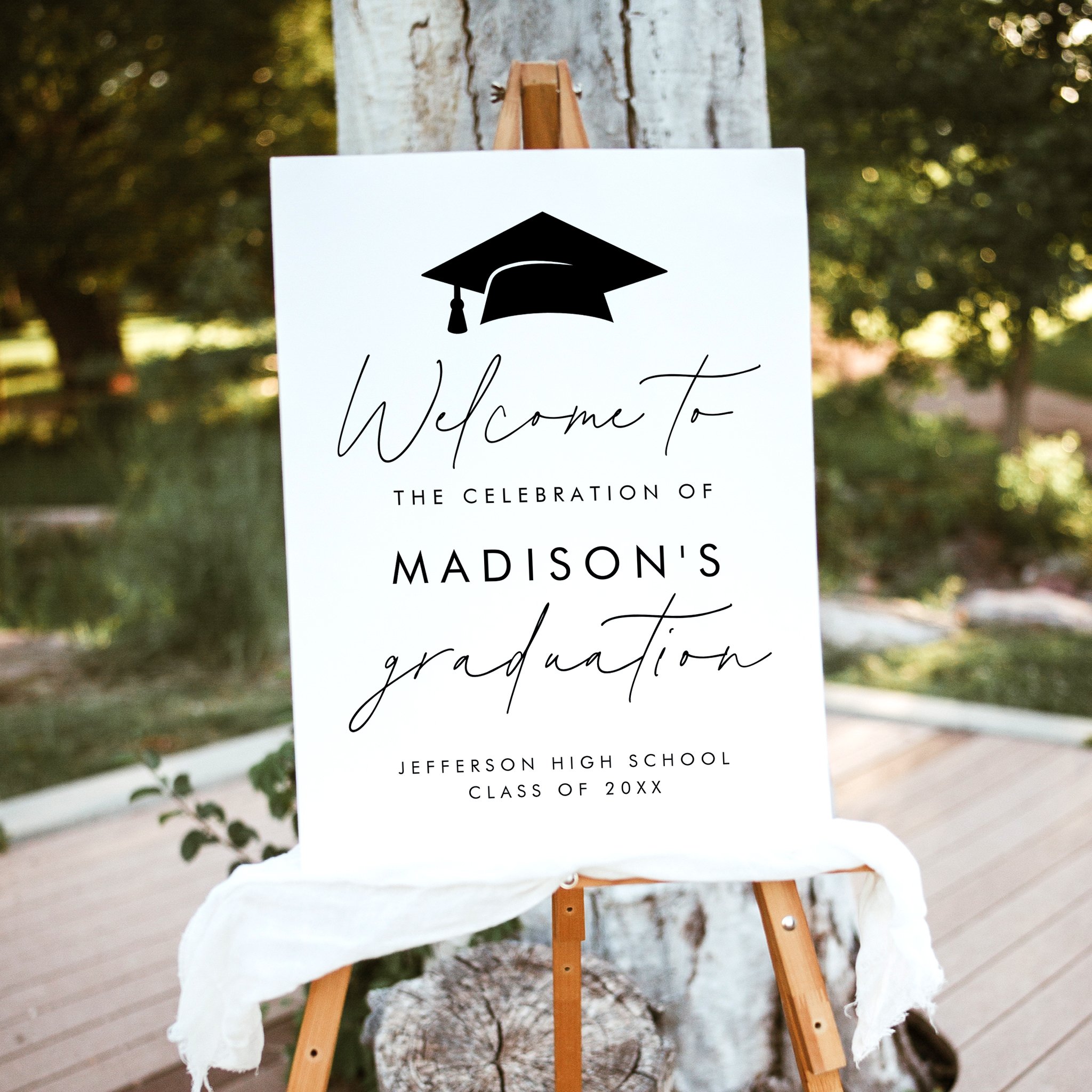 Personalized white graduation party welcome sign with black graduation cap and modern script accents