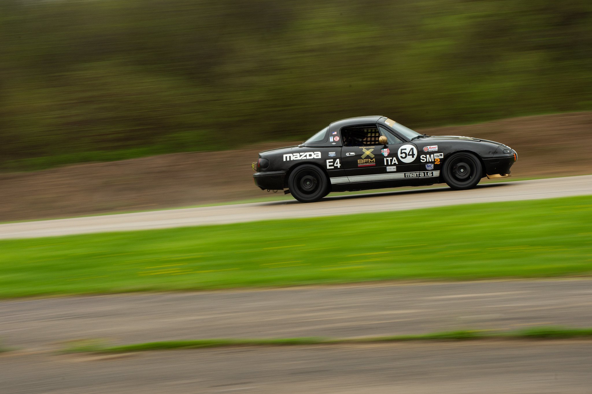 Marcello Cusma's black Mazda Miata challenging the rain conditions