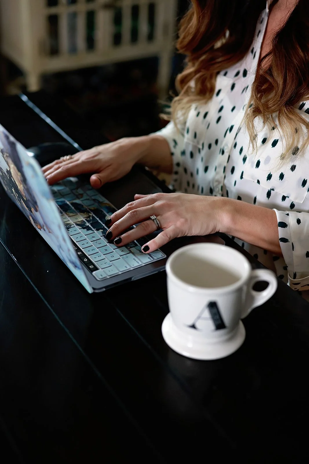 Amanda of ARD Fashion Consulting working at computer with cup of coffee