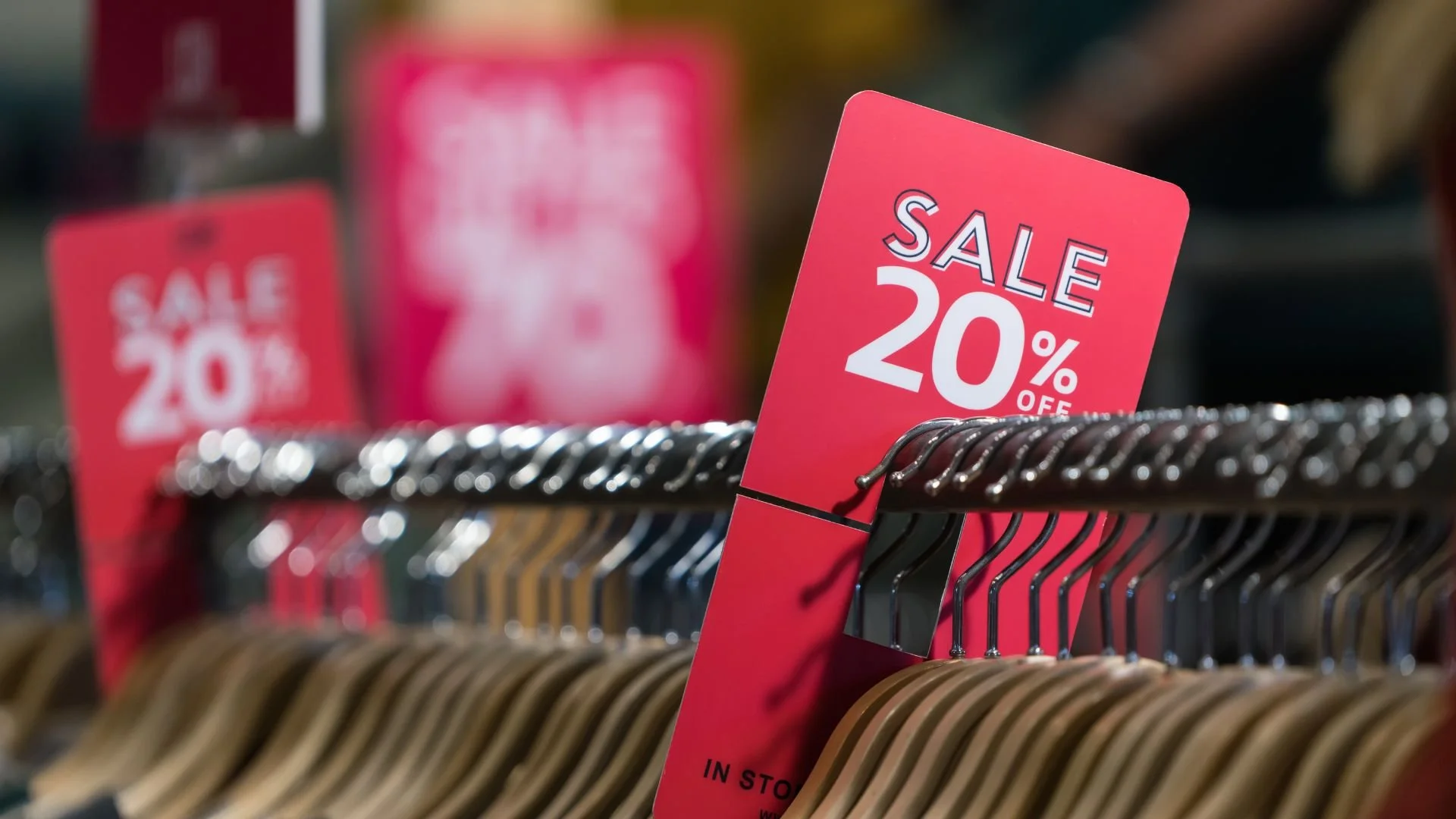 This is an image of many hangers on a rack with a sale tag of 20% off featured in the foreground.