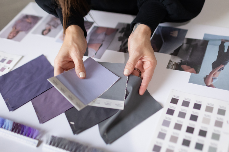 Amanda Rango of ARD Fashion Consulting referencing color swatches of fabric to see how they compliment one another