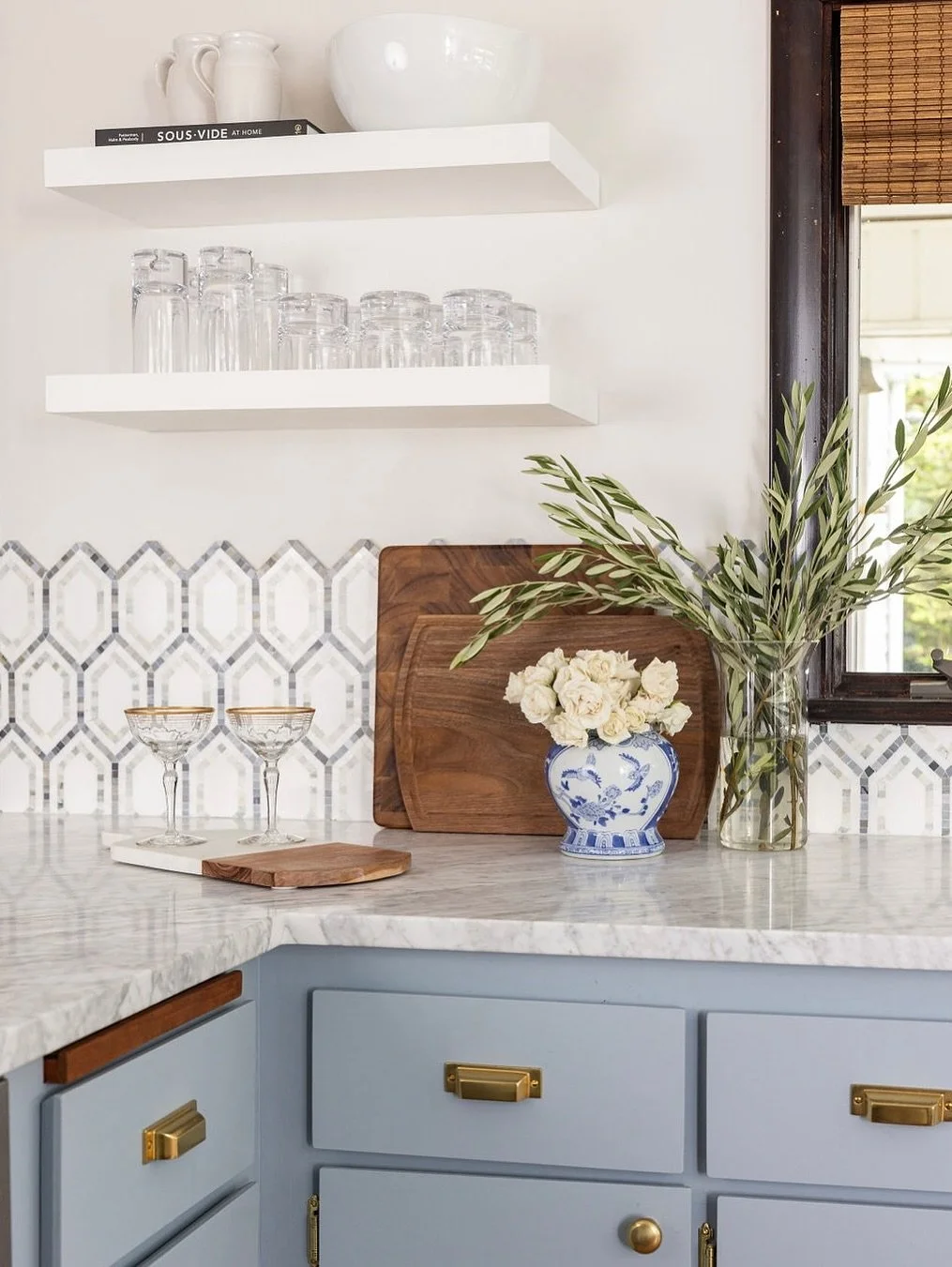 In this traditional New England Cape, the low ceilings were our biggest challenge. Since storage wasn&rsquo;t an issue, we removed the uppers and added open shelving to give the kitchen a lighter, more open feel.

But without uppers, the backsplash b
