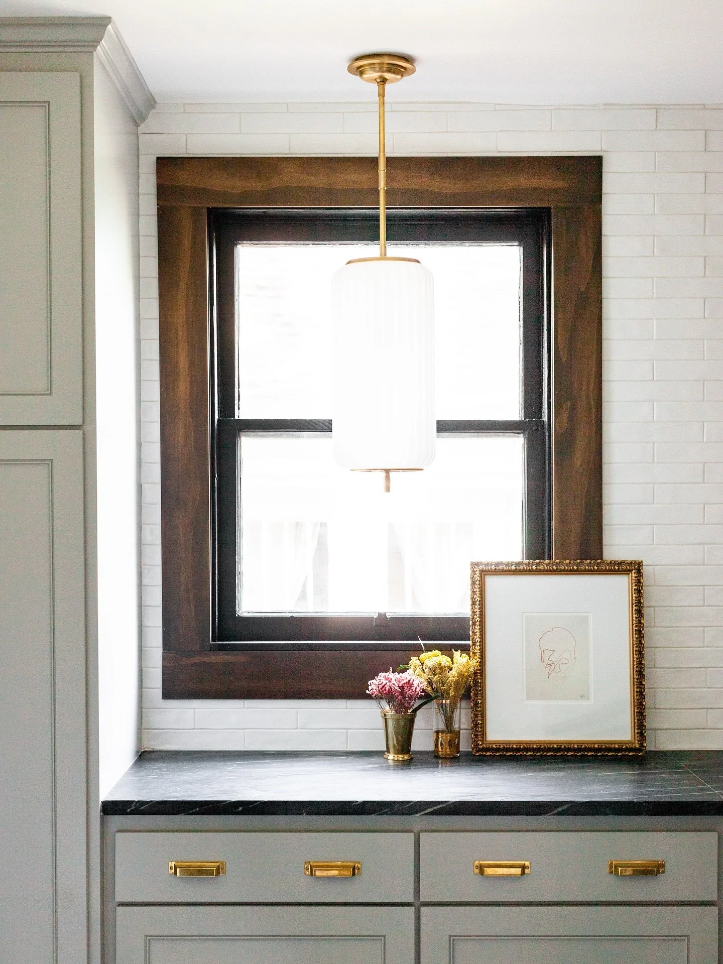 Laundry is boring. By no means should your laundry room be a bore. 

An antique door repurposed as a pocket door with leaded glass matching windows featured throughout the home. 

A gorgeous pendant in front of the window as an accent light for when 