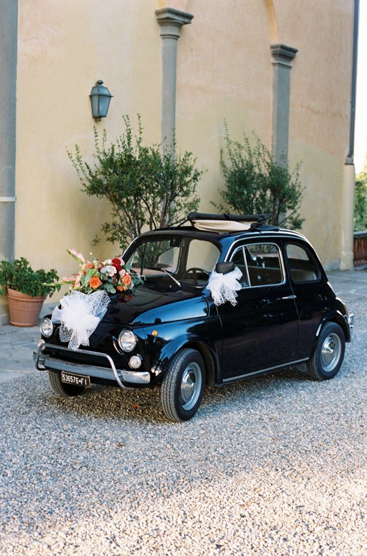 A black Fiat 500 decorated with flowers at the champagne reception in front of Villa Il Poggiale
