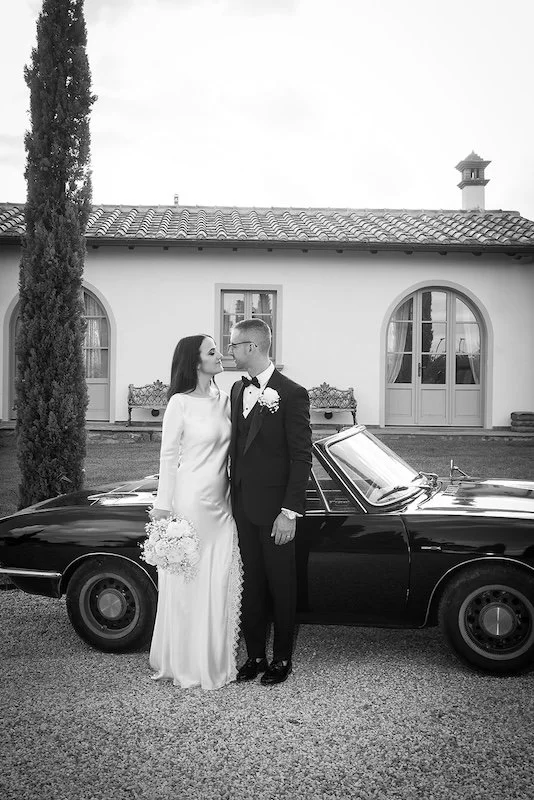 Brautpaar vor einem klassischen Cabriolet bei einer Hochzeit in der Toskana