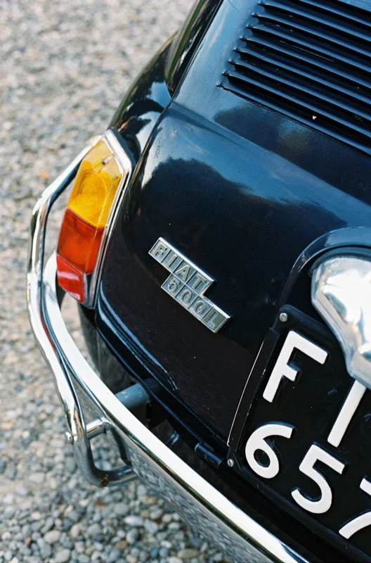 A black Fiat 500 decorated with flowers at the champagne reception in front of Villa Il Poggiale