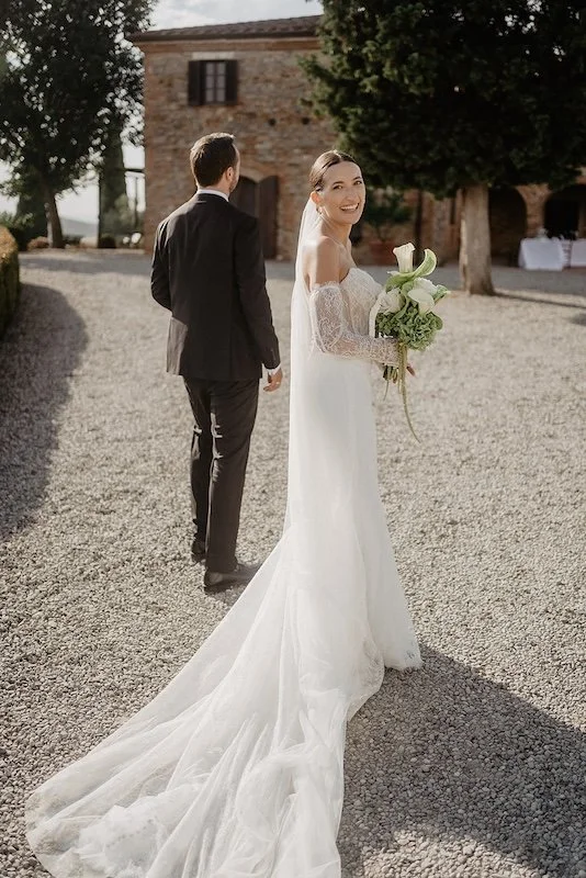 The bride looks back with a smile after the wedding ceremony at Villa Boscarello