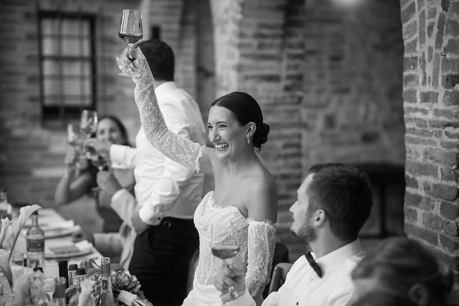 Braut stößt beim Hochzeitsdinner in der Villa Boscarello mit ihren Gästen an