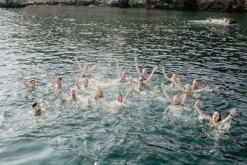 Wedding guests swim together in the sea during a relaxed multi-day wedding in Mallorca