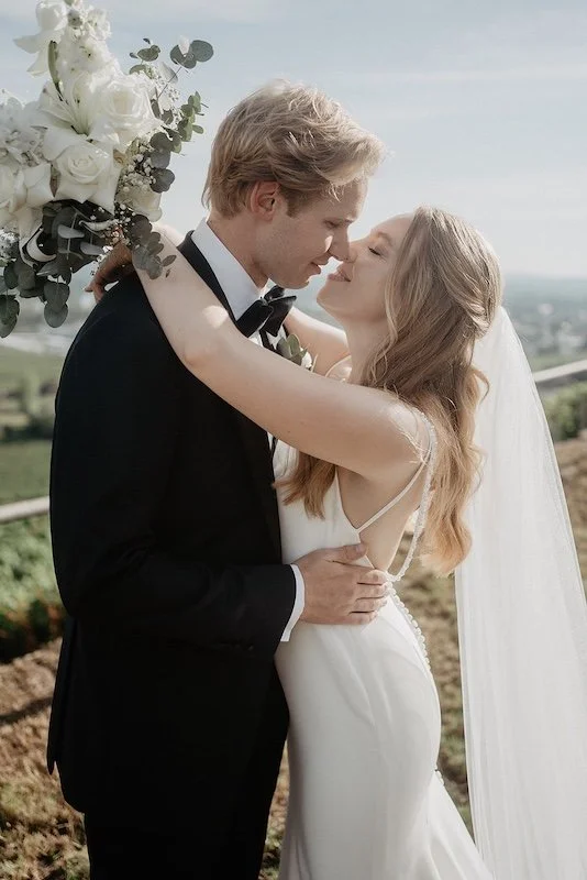 Brautpaar bei einer eleganten Hochzeit im Rheingau beim Kuss im warmen Sonnenlicht