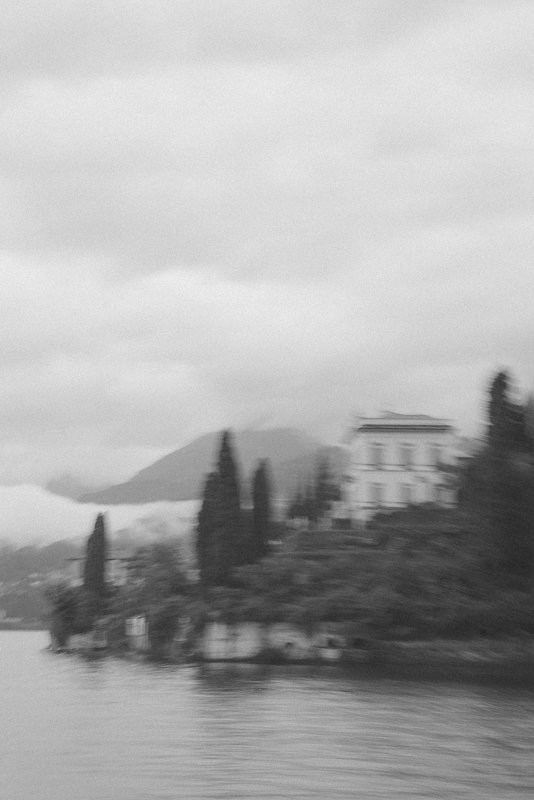 Italienische Villa am Gardasee in malerischer Hanglage - verträumte Schwarz-Weiß-Fotografie mit Nebel im Hintergrund.