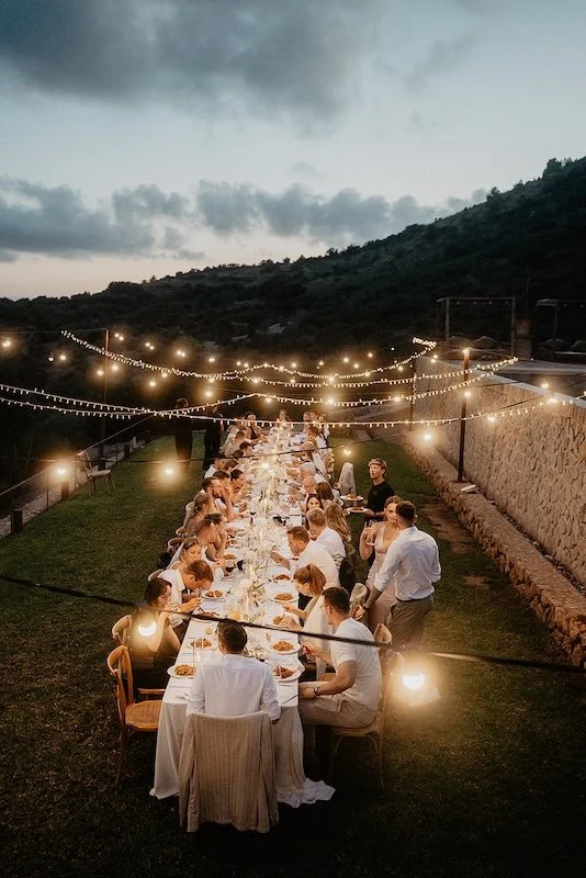 Abendliches Hochzeitsdinner auf Mallorca mit Lichterketten – gemeinsames Dinner bei einer mehrtägigen Hochzeit im Freien.