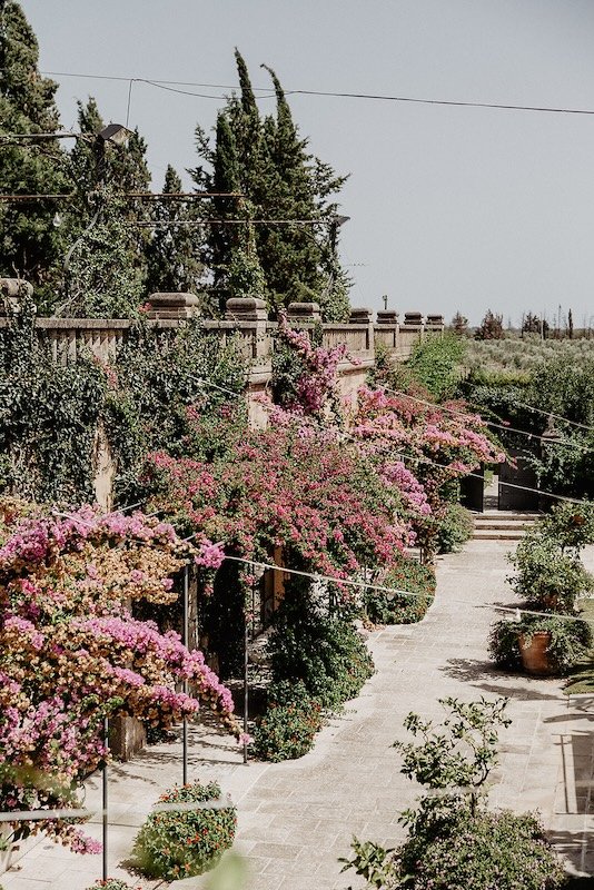 Weg mit blühender Bougainvillea zwischen den Gärten von Castello Monaci