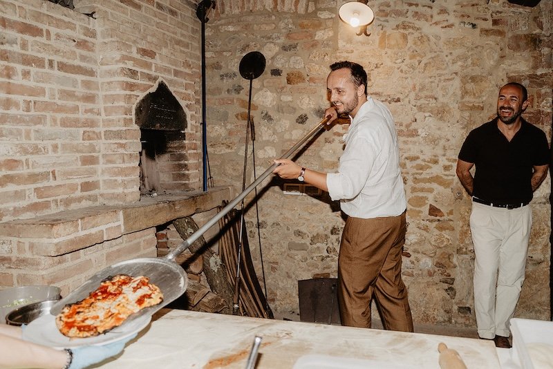 Groom Daniel bakes his own pizza in the stone oven at Villa Boscarello