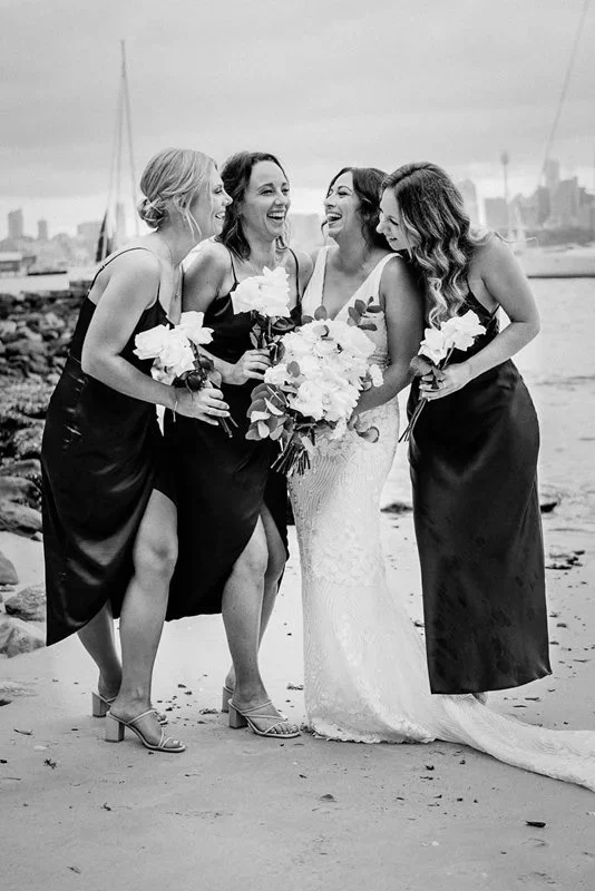 Braut mit Brautjungfern am Meer während einer Hochzeit