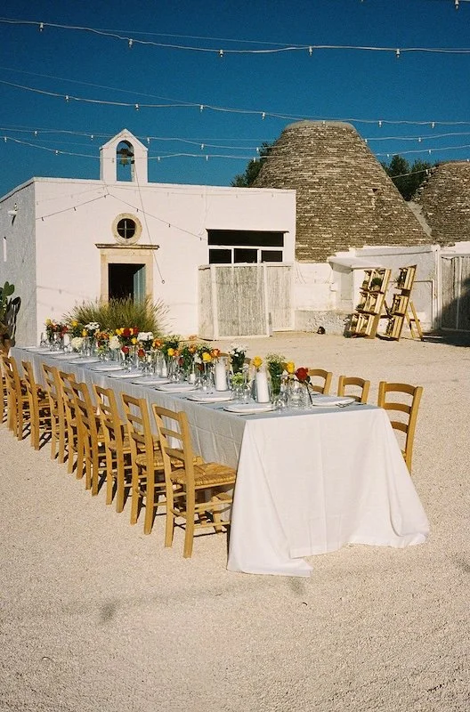 Lange festlich gedeckte Tafel im Innenhof der Masseria Mozzone für die Hochzeitsfeier in Apulien