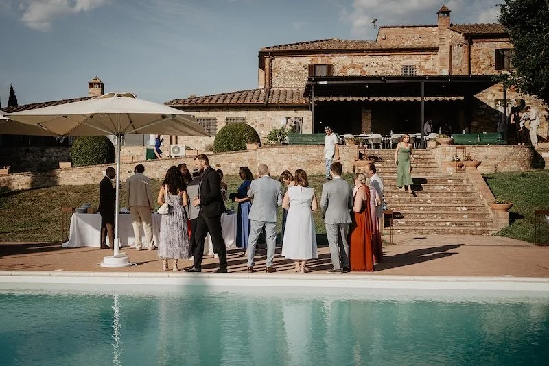 Wedding guests enjoying an aperitivo by the pool at Villa Boscarello in Tuscany