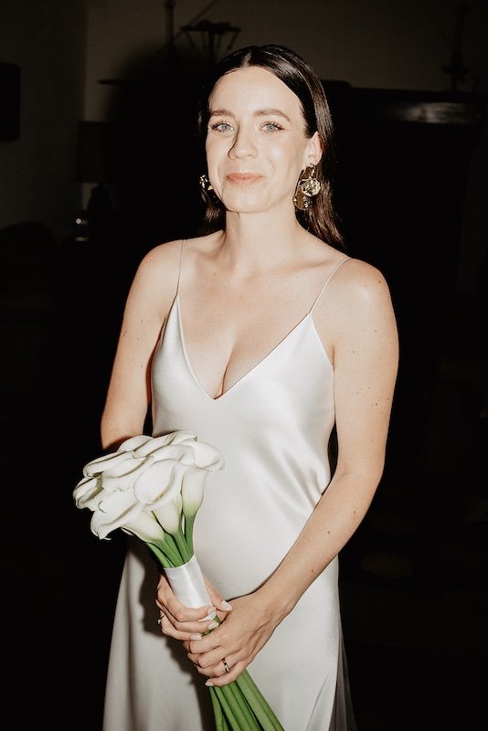Braut mit schlichten Calla-Blumen und glänzendem Seidenkleid - romantische Hochzeitsfotografie am Gardasee.