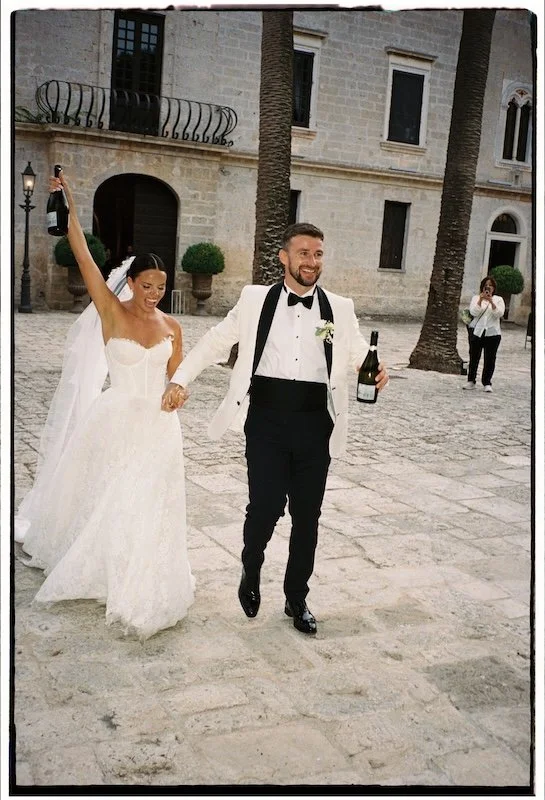 Brautpaar mit Champagner nach der Trauung im Castello Monaci in Apulien auf 35mm Film
