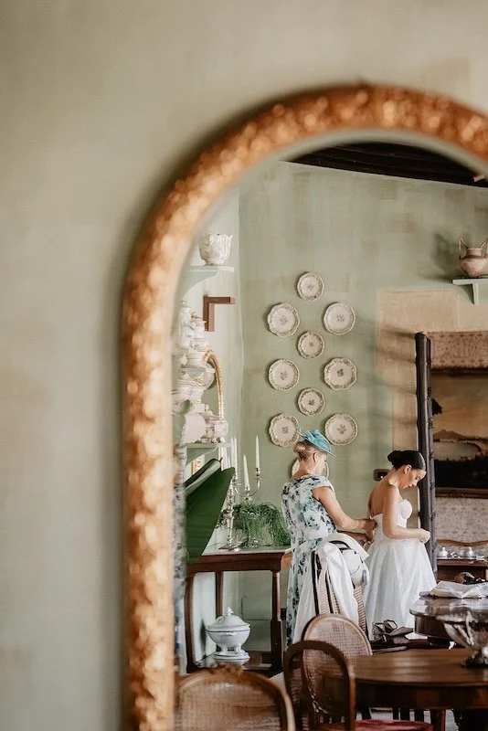Braut wird beim Getting Ready in einem historischen Zimmer in Castello Monaci angezogen