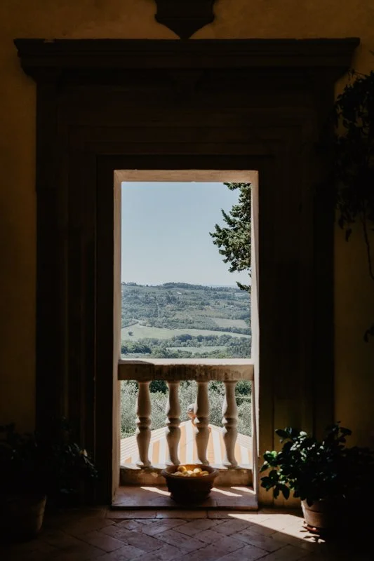 View through a historic door at Villa Il Poggiale toward the Chianti hills