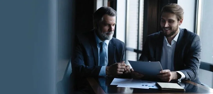 Two business professionals reviewing documents together in a professional consultation setting.