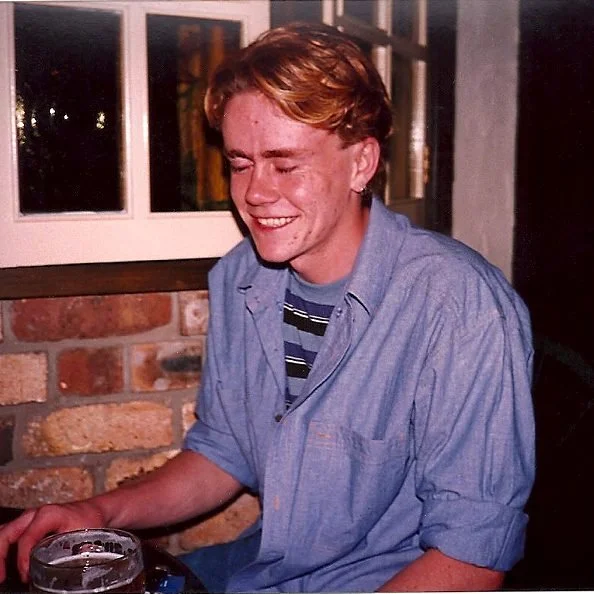 Christopher Drury aged 20, smiling with his eyes closed