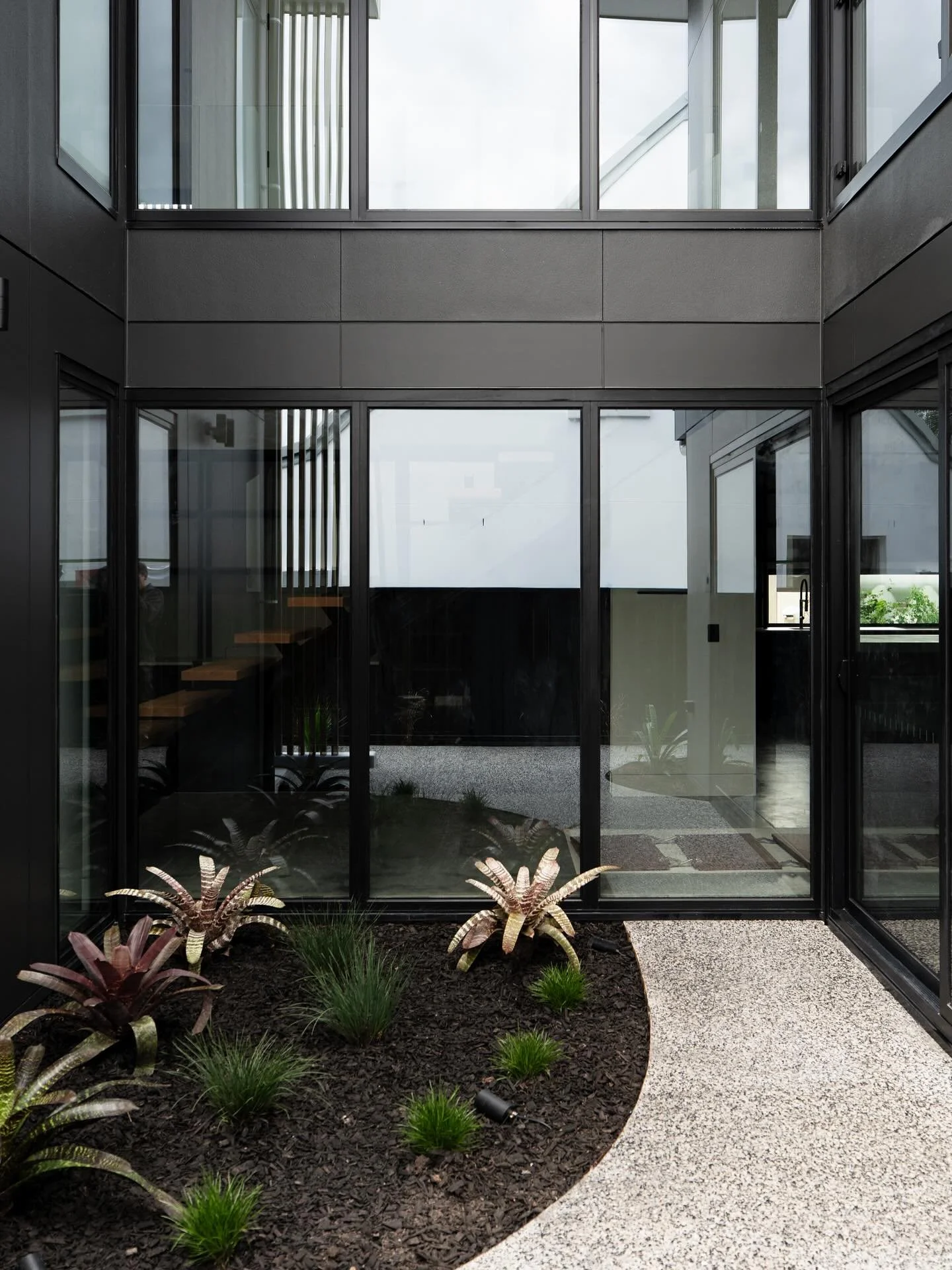 Paired back landscaping to compliment the dark facade.