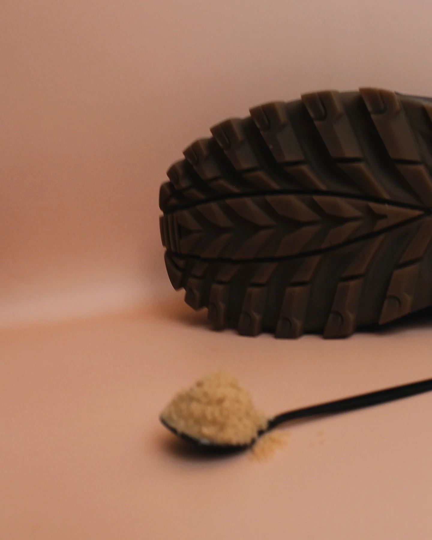 A brown leather boot with a teaspoon of brown sugar.