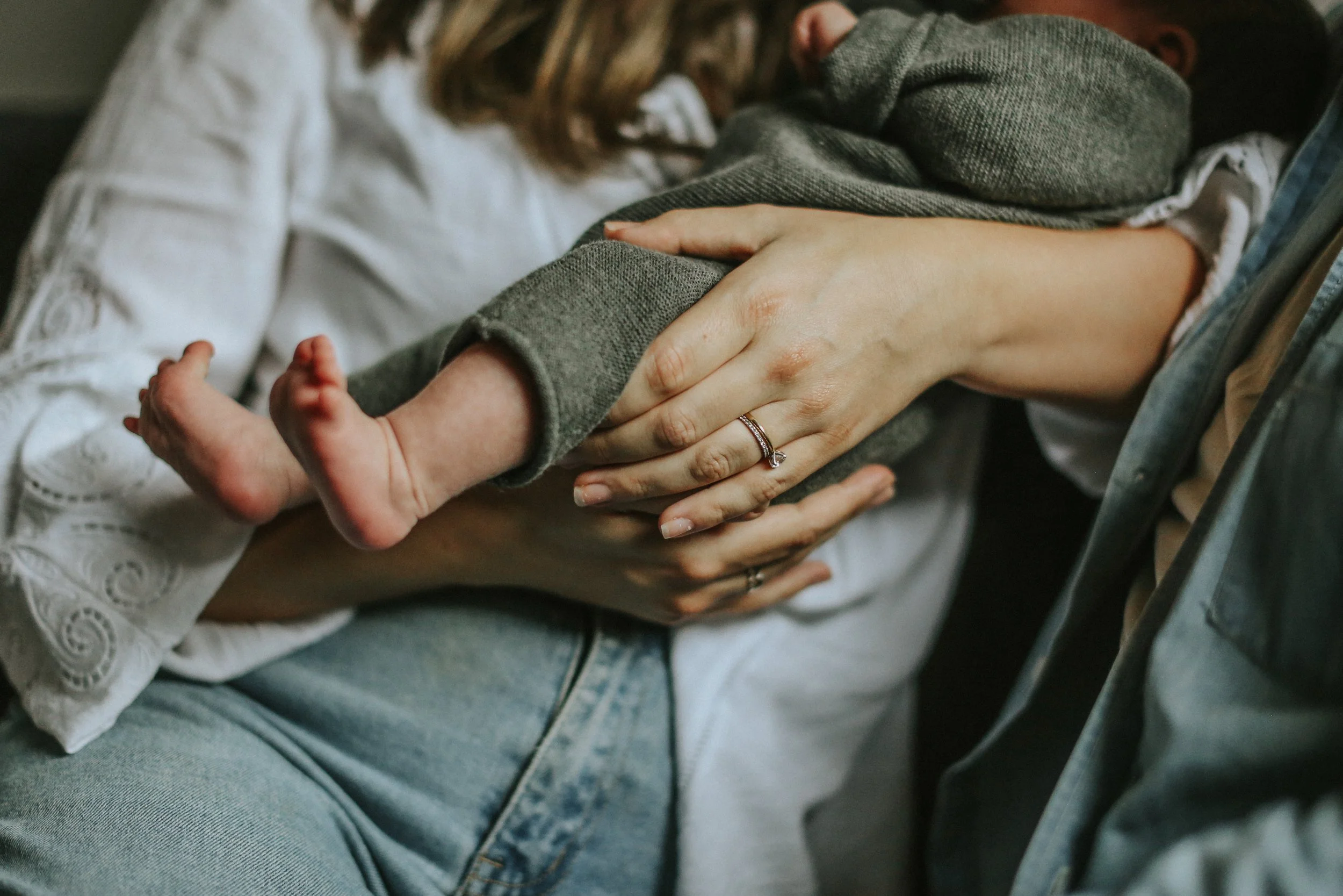 A newborn's hands held by parents, supported by Romy Baron Doula in Melbourne