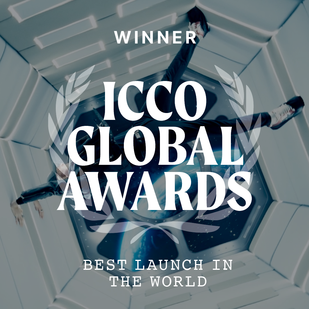 An astronaut in a spacecraft's space station with a view of Earth through a window, celebrating as the winner of the ICCO Global Awards for best launch in the world.