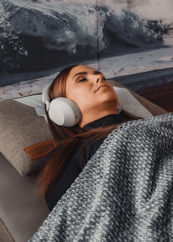 nainen neurosonic-rentoutuksessa silmät kiinni