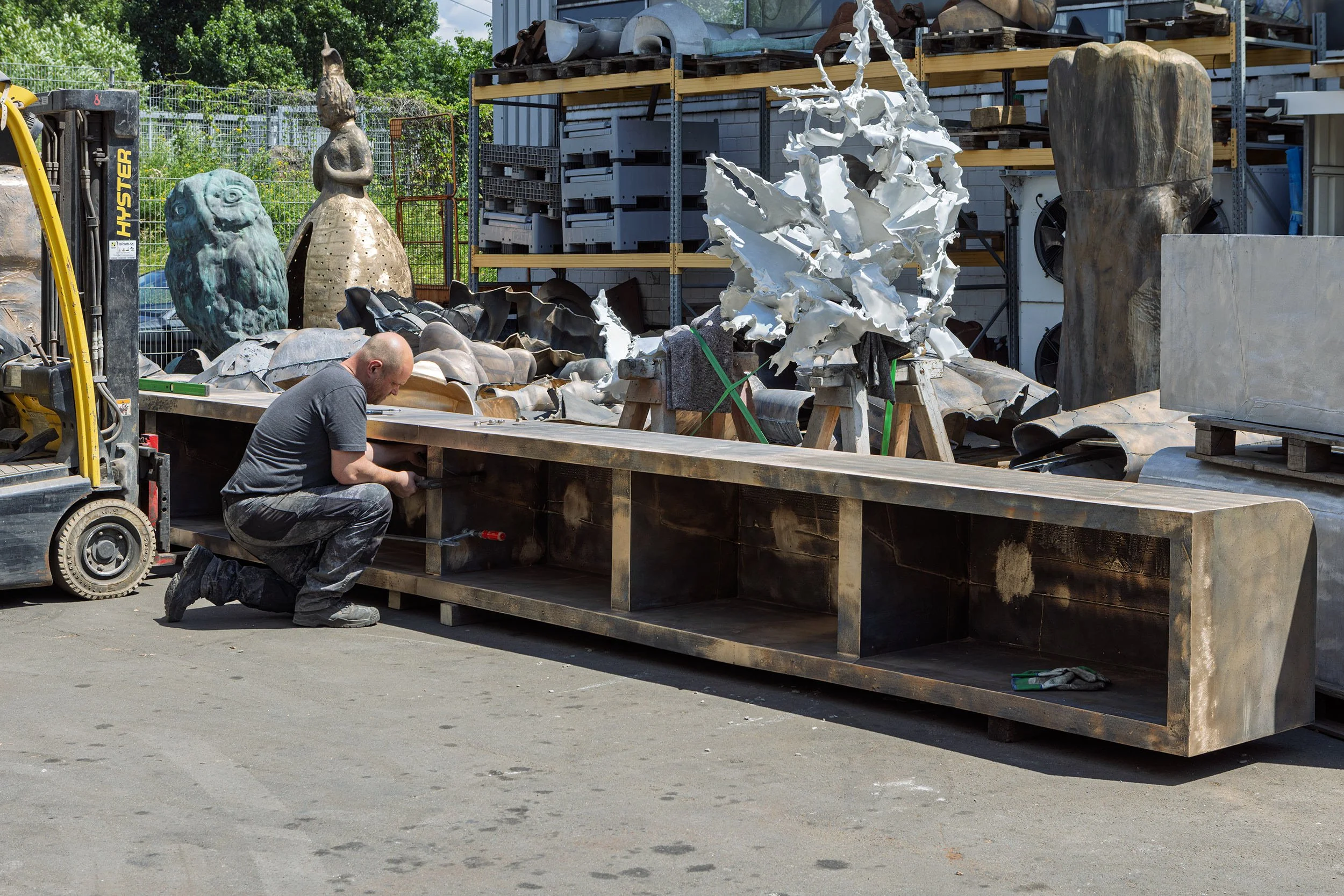 Ein Metallbildner bei der Montage zweier Bronze-Skulpturen