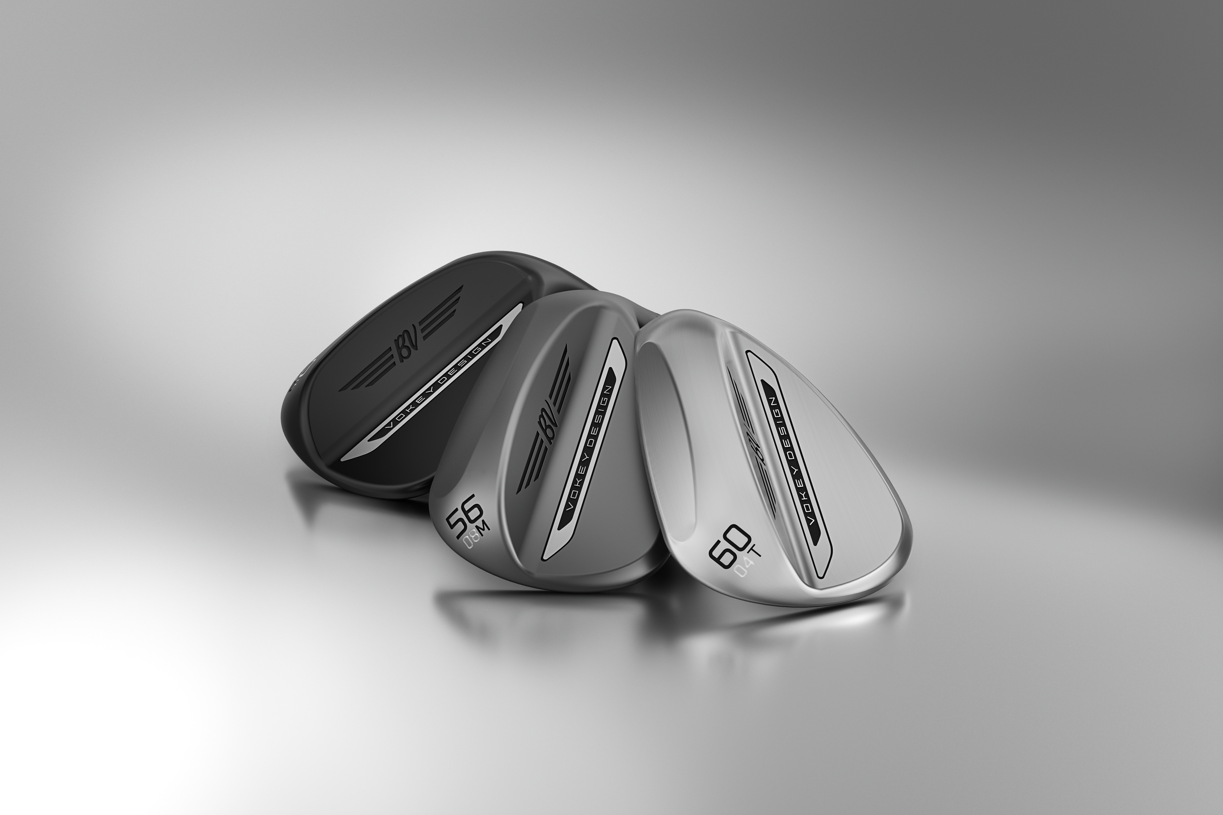 Tre golfklubbor i svart, mörkgrå och silver färg