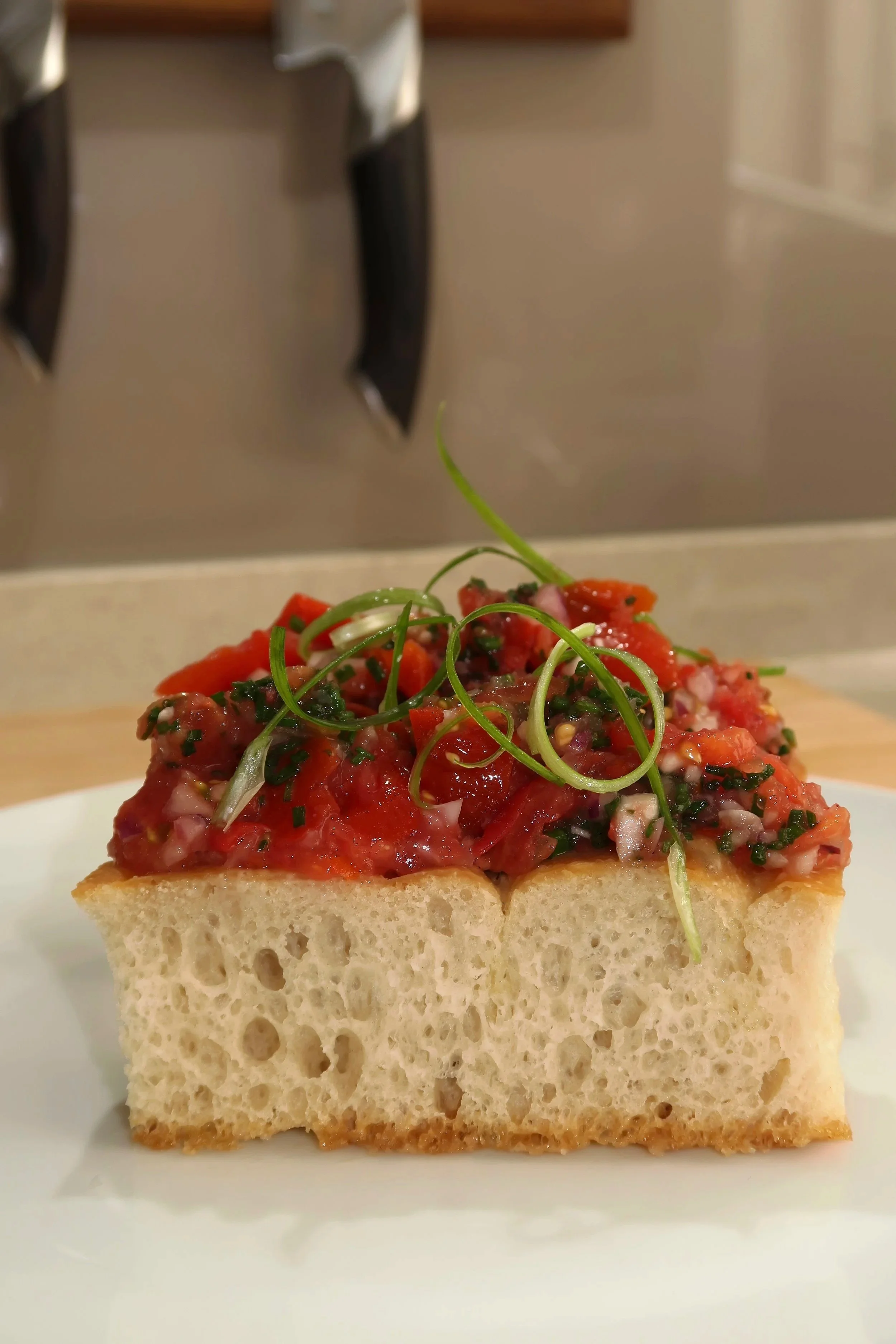 Tomato Bruschetta on Focaccia  
Vine-ripened tomatoes with fresh chives and red onion, dressed in extra-virgin olive oil, served on house-made focaccia, and finished with scallion curls.