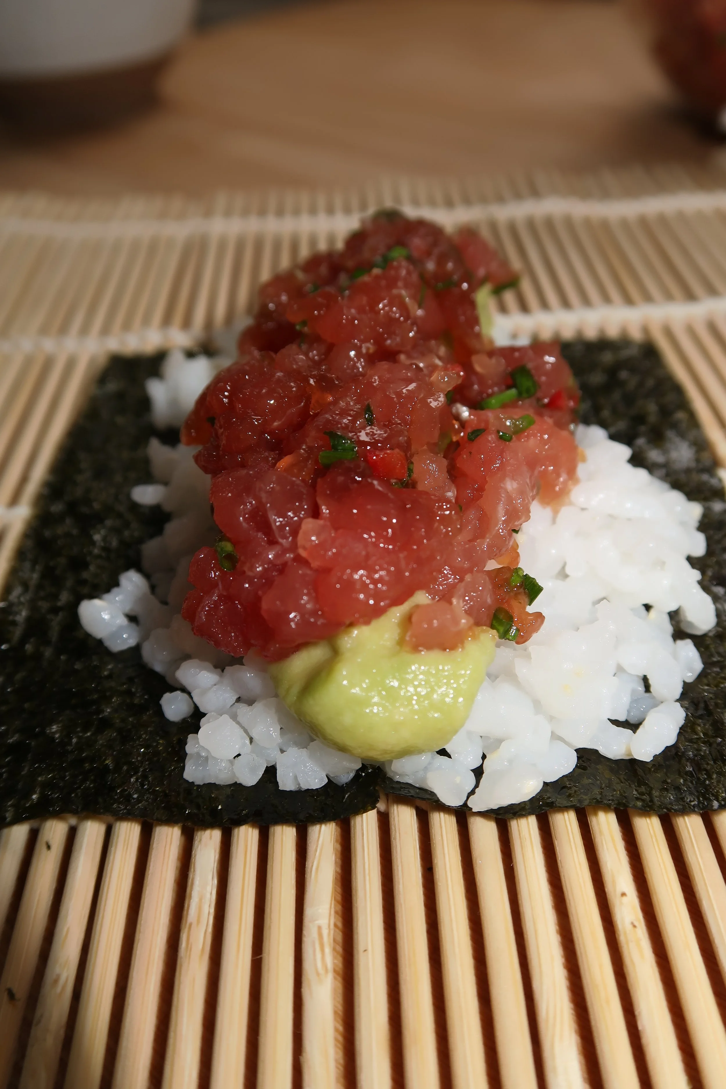 Spicy Tuna and Avocado Handroll  Sushi rice layered over crisp nori with avocado mousse and spicy marinated tuna tartare.