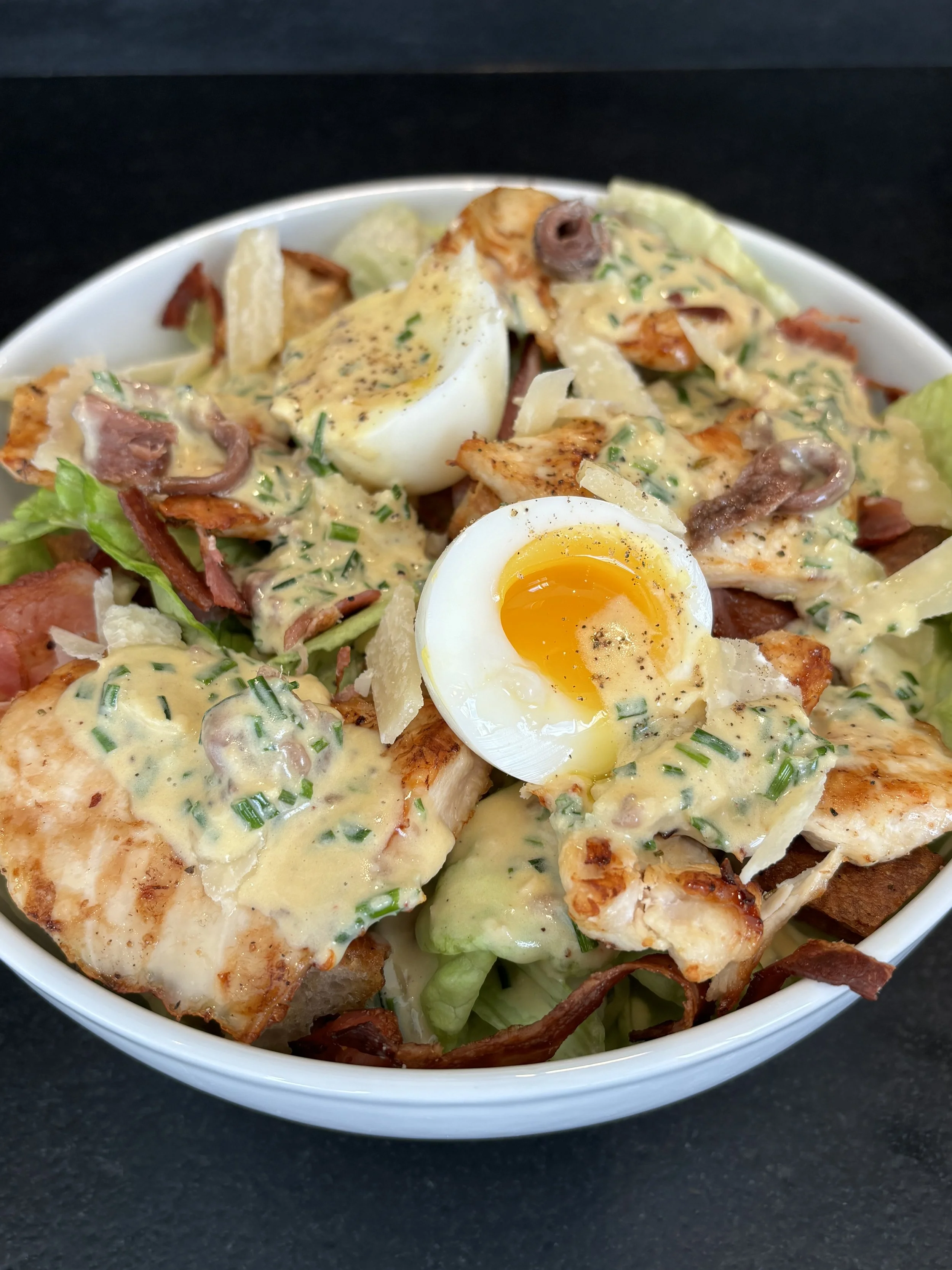 Grilled Chicken Caesar Salad  
Grilled chicken breast served over crisp romaine hearts with garlic croutons, shaved Parmigiano-Reggiano, and traditional Caesar dressing, finished with freshly cracked black pepper.